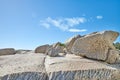 Big boulders on a rocky coast outside on a summer day. Landscape view of a beautiful beach and seashore under a clear Royalty Free Stock Photo