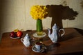 A big bouquet of yellow daffodils in a vase on a wooden table, with apples. morning tea Royalty Free Stock Photo