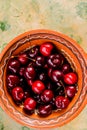 Big bowl with many large red juicy tasty sweet cherries.Fresh cherries berries in bowl on green rustic wooden background Royalty Free Stock Photo