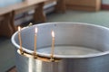 Big bowl of water for the baptism of a baby with wax candles. Orthodoxy. Greek Catholics Royalty Free Stock Photo