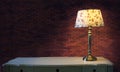 Big brick wall and light lamp on white table Royalty Free Stock Photo