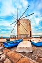 A big brick windmill with three old fish boats, Corfu, Greece Royalty Free Stock Photo