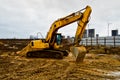 Big bright yellow powerful industrial heavy excavator tractor, bulldozer, specialized construction equipment for road repair Royalty Free Stock Photo