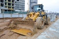 Big bright yellow powerful industrial heavy excavator tractor, bulldozer, specialized construction equipment for road repair Royalty Free Stock Photo