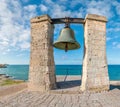 Big bronze bell on the sea shore in the ancient Greek city Chersonesus, Hersones in Sevastopol, Crimea. Copy space. Travel and Royalty Free Stock Photo