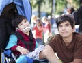 Big brother taking care of disabled brother in wheelchair