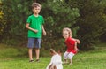 Big brother teaches his sister to throw ball and play fetch with their pet dog Royalty Free Stock Photo