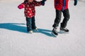 Big brother teaching little sister to skate in winter