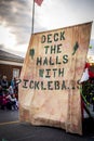 A big brown and green sign in a Christmas parade