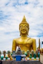 Big Buddha sculpture in temple with blue sky and clouds