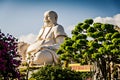 Big buddha statue in a garden of a Vietnamese temple. My Tho Vinh Trang Temple. (Ho Chi Minh City, Vietnam - 2/01/2020