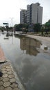 Big building reflection in waterlogged puddle during monsoon