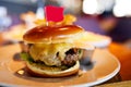 Big burger with a flag on top stands on a plate Royalty Free Stock Photo