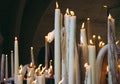 Big burning candles from prayers for hope. Saint Bernadette grotto with many white candles with flame. Sanctuary in Lourdes.