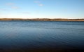 Big calm rural lake with panoramic view of the village and forest far away on the opposite side in the autumn day Royalty Free Stock Photo