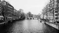 Big canal Singel in Amsterdam with bridge in the background in black & white