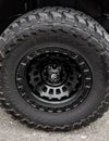 Big car wheel on a road. Closeup of big 4x4 car wheel of mountain track. Offroad 4x4 concept Royalty Free Stock Photo