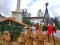 Big carved wood figures in public christmas crib wooden outdoors at central plaza with church in background