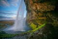 Big cave behind The Seljalandsfoss waterfall in Iceland with evening sky Royalty Free Stock Photo