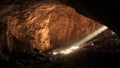 Big cave with bright sunbeam from entrance