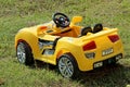 big children& x27;s yellow car on green grass Royalty Free Stock Photo