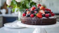 A big Chocolate cake with fresh berries on a white kitchen countertop closed-up Royalty Free Stock Photo