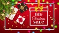 Big Christmas sale background with golden gifts bow under fir tree. Christmas decoration, confetti, light garlands on a Royalty Free Stock Photo