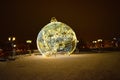 A big Christmas toy on the background of street lamps and the night sky Royalty Free Stock Photo