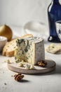 Big chunk of delicious Gorgonzola cheese on a table with walnuts bread. Traditional Italian cuisine specialty