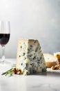 Big chunk of delicious Gorgonzola cheese on a table with walnuts glass of red wine. Traditional Italian cuisine specialty