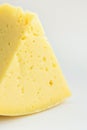 Big Chunk Wedge of Alpine Creamy Appetizing Light Yellow Tilsit Cheese on White Background. Texture with Cracks and Holes