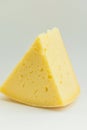 Big Chunk Wedge of Alpine Creamy Appetizing Light Yellow Tilsit Cheese on White Background. Texture with Cracks and Holes