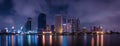 Big city in the night life with reflection of water wave. Long exposure Technics. Panorama of landscape.Town and urban concept.