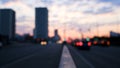 Big city street in the evening with bokeh and blur effect. Concept. Sunset sky, high rise buildings and moving cars Royalty Free Stock Photo