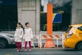 Two asian girls standing in front of steam chimny about to cross the street in New York City