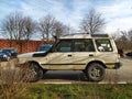 Big classic veteran dented rusty dusty British 4WD car Land Rover Discovery left side and front view