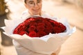 Big classy bright bouquet of red roses in hands of cute girl. One hundred and one roses Royalty Free Stock Photo