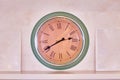 Big clock on the shelf. Blank photo frames on the wall. Green and beige color of the clock antique Royalty Free Stock Photo