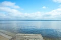 Big clouds reflecting on the smooth water surface. Warm windless autumn day near the lake or a sea.