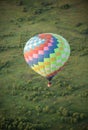 A big colorful balloon flying over the green field using heat technology