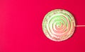 Big colorful spiral meringue  on red background. Festive and party concept. Minimal style. Flat lay. Top view. Copy space Royalty Free Stock Photo