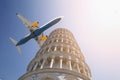 Big commercial passenger airplane flying over leaning tower of Pisa in Italy on bright sunny day. Visit Italy concept. Travel to