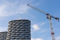 Big construction crane next to high-rise modern apartments