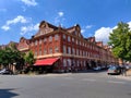 Big corner municipal house made of red bricks with a restaurant in the basement seen from the other side of the crossroads Royalty Free Stock Photo