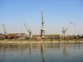 Big Cranes in a shipyard with rails next to water Royalty Free Stock Photo