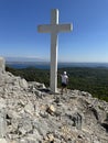 Big cross against the background of the sea. A man near the Christian monument Cross of Jesus. Croatia, Ugljan island, near the
