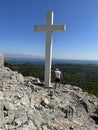 Big cross against the background of the sea. A man near the Christian monument Cross of Jesus.