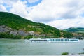 Big cruise ship on Danube river and mountains in background. Royalty Free Stock Photo