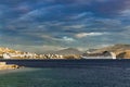 Big cruise ship sails to the sea port of Saranda, Albania. Albanian mountains at the background. Sunset, cloudy sky Royalty Free Stock Photo