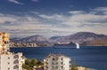 Big cruise ship sails to the sea port of Saranda, Albania. Albanian mountains in the background. Sunset, cloudy sky Royalty Free Stock Photo